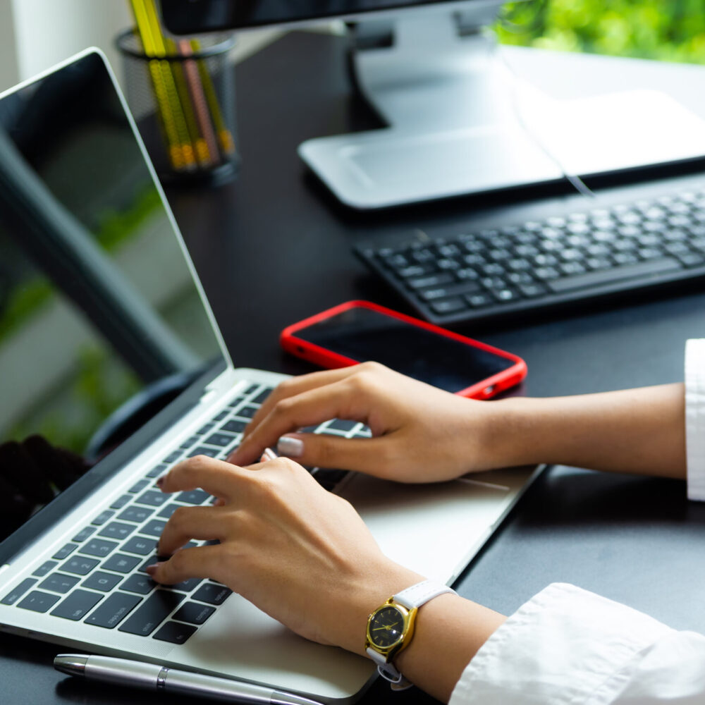 Female hand typing on keyboard of laptop digital marketer
